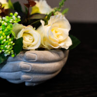 Troostend bloemstuk in handen