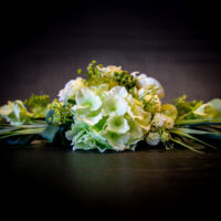 Langwerpig bloemstuk met witte en groene bloemen